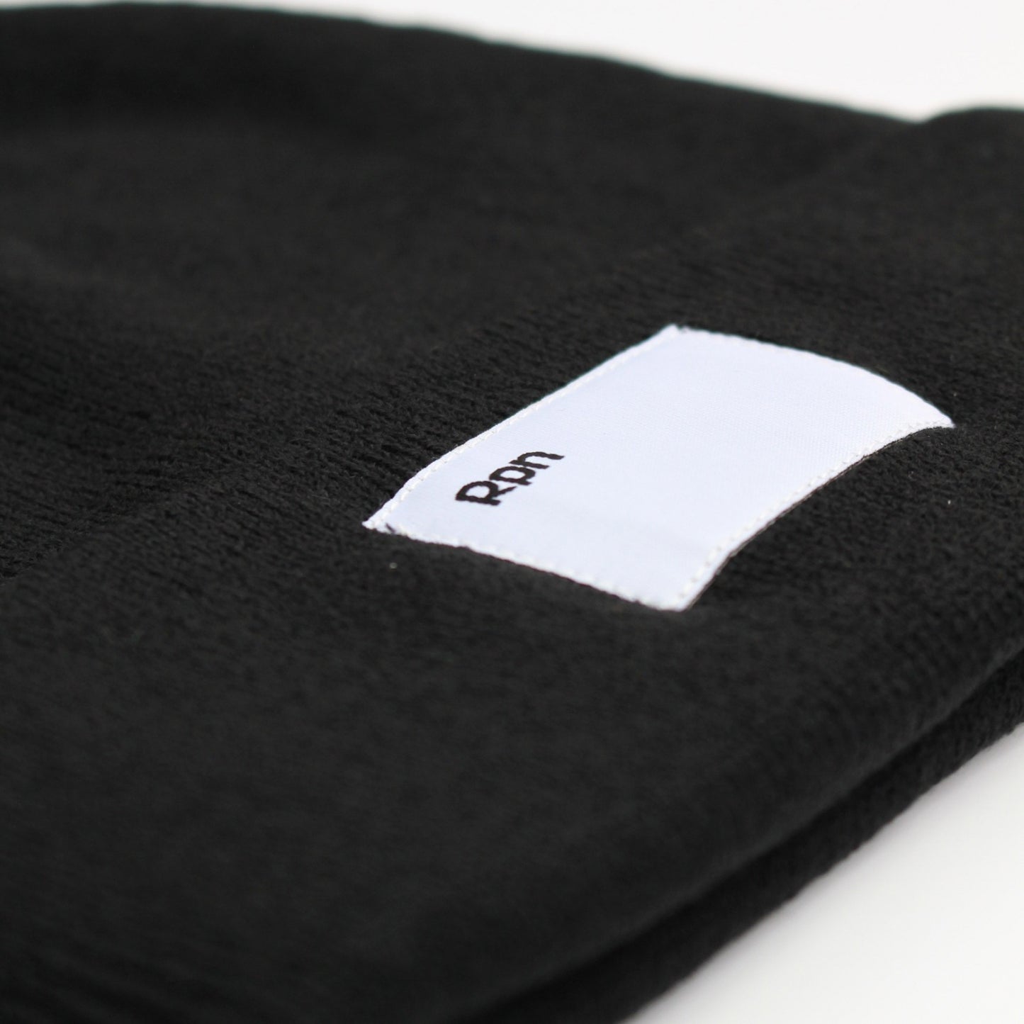 wide fit beanie in black with woven label